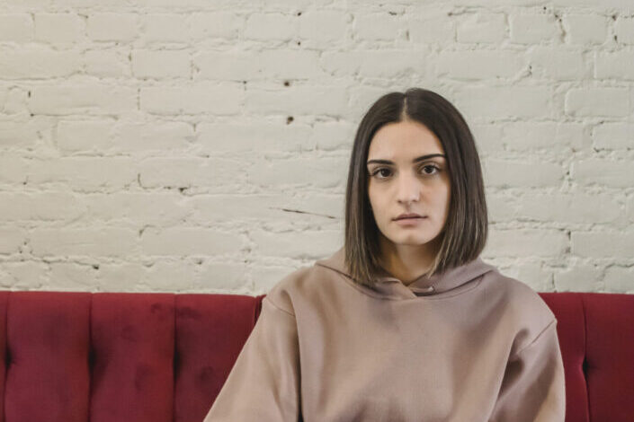 Woman Sitting on a Red Sofa