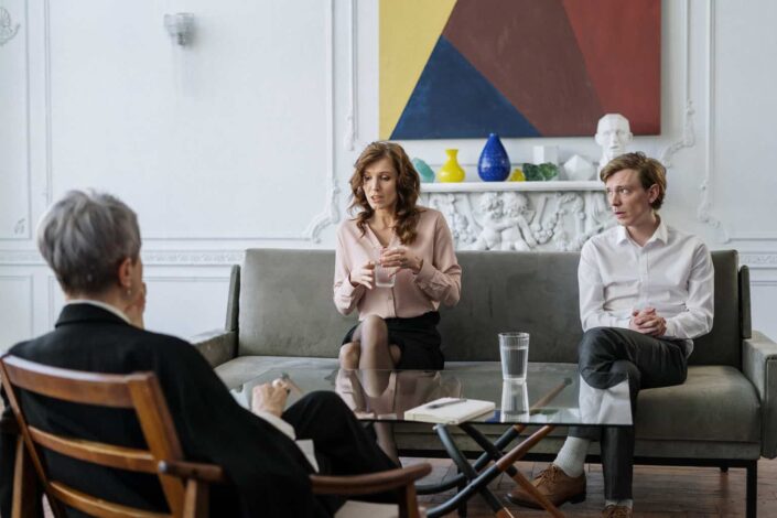 Woman in pink long sleeve shirt sitting on gray couch