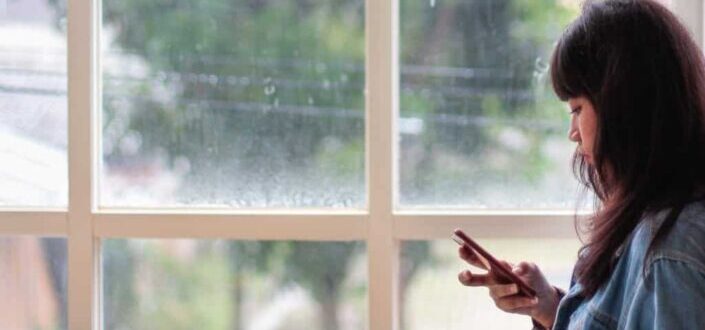Woman Standing Beside Clear Glass Window