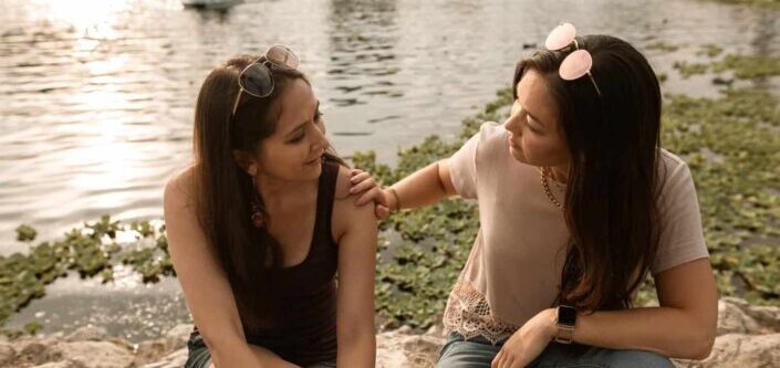 Women Sitting and Talking by a Lake