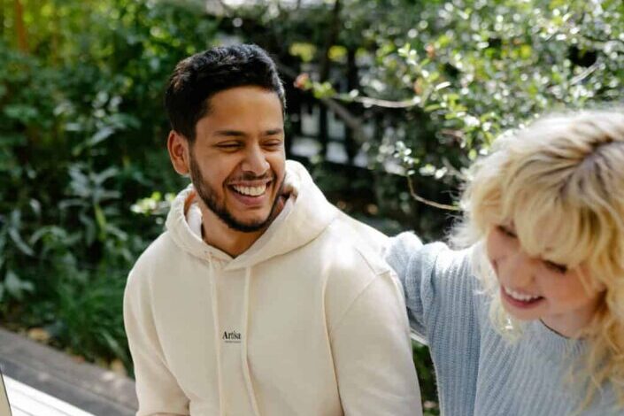 Couple Sitting on a Bench Laughing