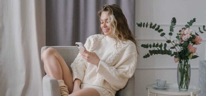 A woman using her smartphone while sitting