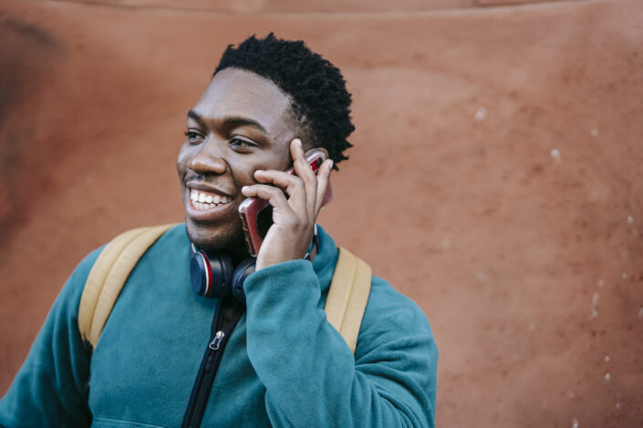 Joyful Guy Talking on Smartphone on Street
