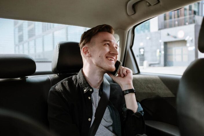 Man Sitting Inside a Car While Talking to Someone on the Phone
