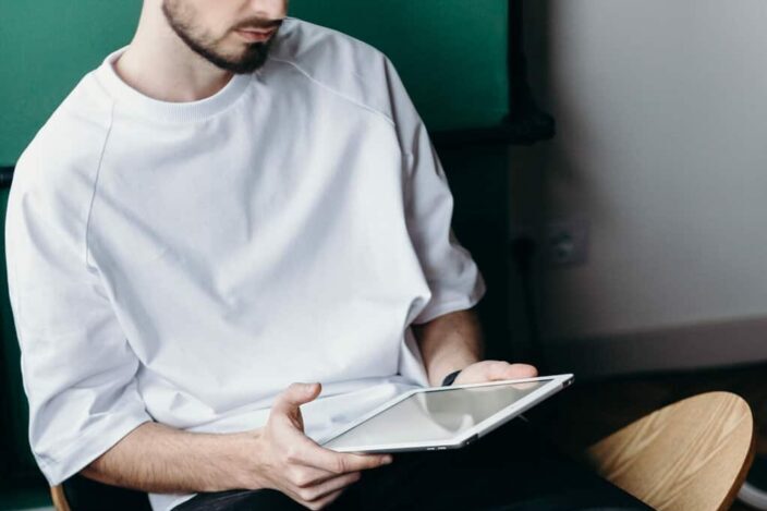 Man in White Shirt Sitting on Brown Wooden Chair