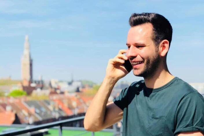 Man Wearing Crew Neck Shirt Holding a Mobile Phone to His Ear