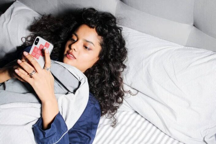 Woman in blue sleepwear lying on bed