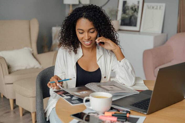 Woman Talking on the Phone and Browsing Through Brochure