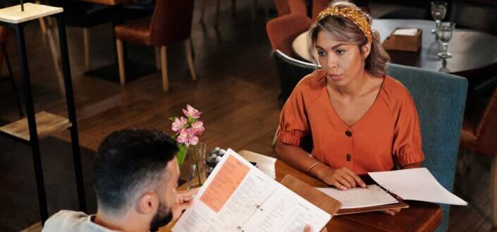 A couple choosing from the restaurant menu