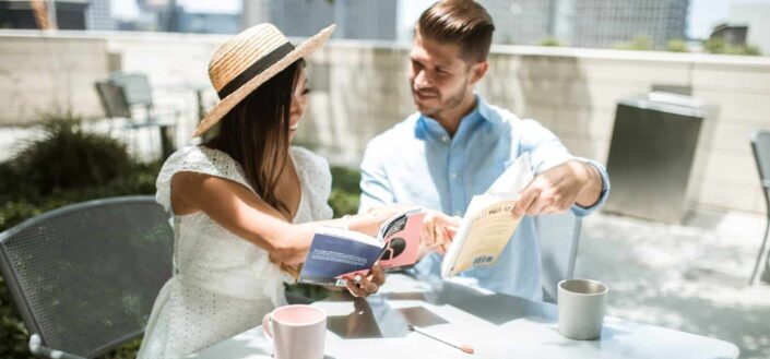 couple sitting on chairs reading books