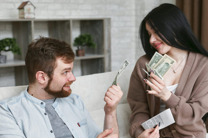 A man and woman holding money