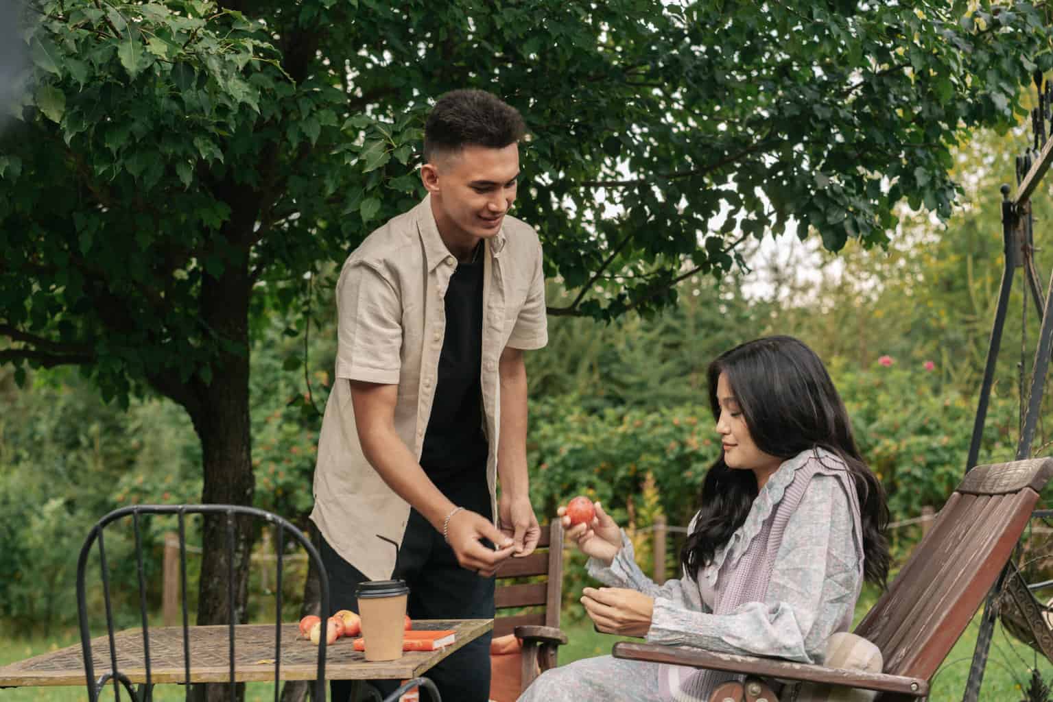 A man giving an apple to a woman