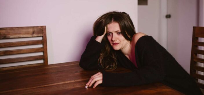 A sad woman leaning on the table