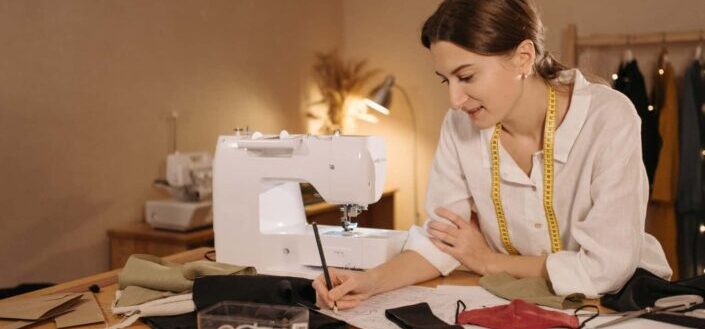 Young dressmaker drawing a pattern on paper