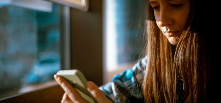 A Woman Using Her Phone by the Window