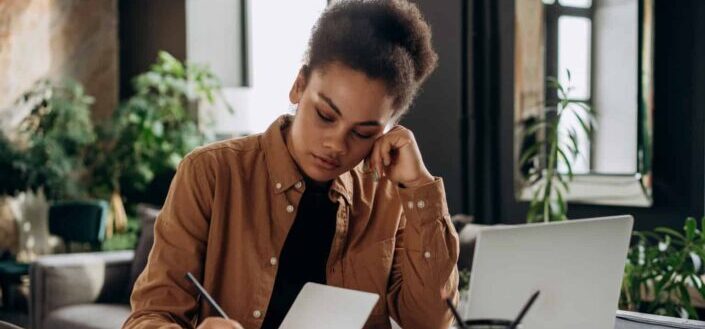 A woman writing on a notebook