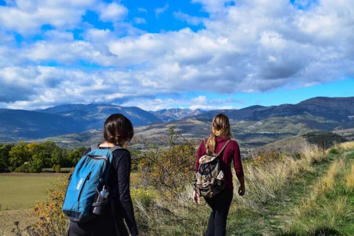 young ladies hiking on grassy terrain