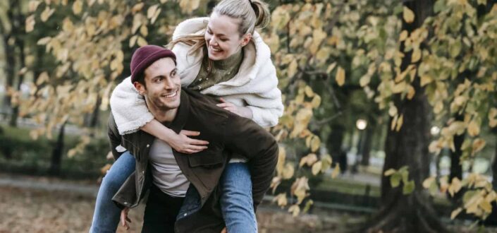 man giving piggyback ride to smiling girlfriend 