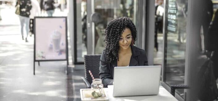 ethnic young woman using laptop in cafe