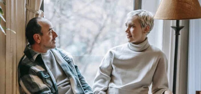 Happy couple resting on couch while talking
