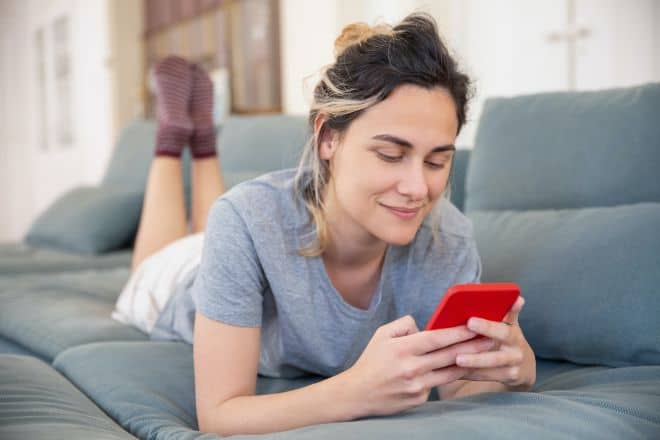Woman On Sofa Using Her Cellphone - How To Talk Dirty To Him On Text