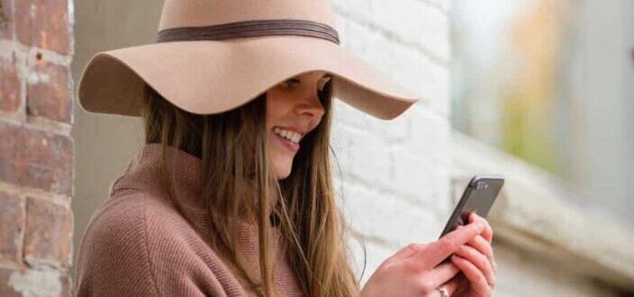 woman smilling while texting