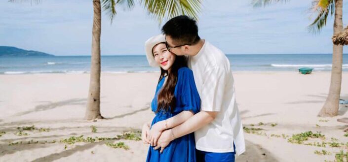 man kissing woman at beach