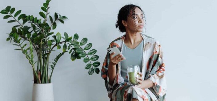 Woman Sitting Beside an Indoor Plant