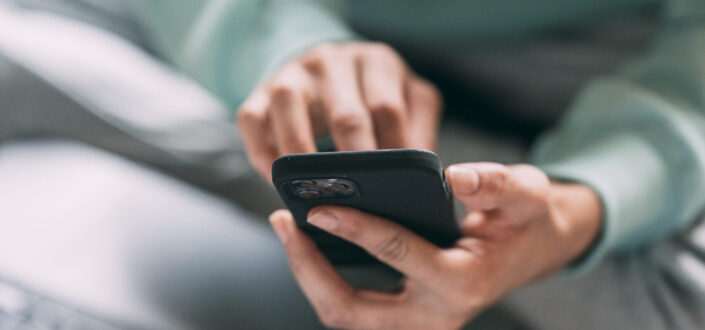 Man Browsing Smartphone on Bed