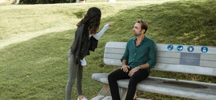 Woman in jacket pointing at a man