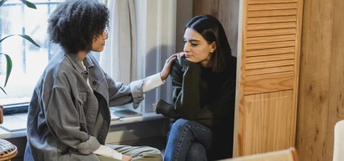 Young woman supporting upset female friend