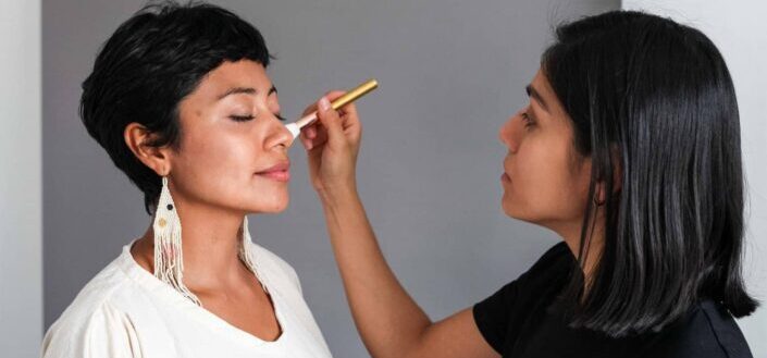 A makeup artist applying makeup on a woman