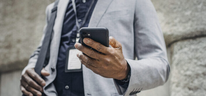 businessman browsing smartphone on street