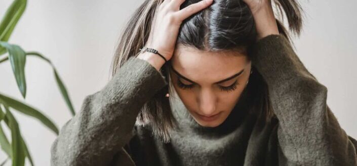 sad lady touching head and looking down