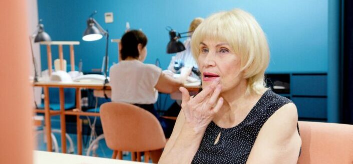 Elderly woman fixing her lipstick