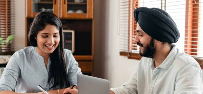 Happy indian couple doing homework together