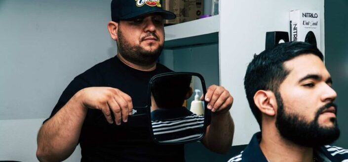 Man holding mirror behind man