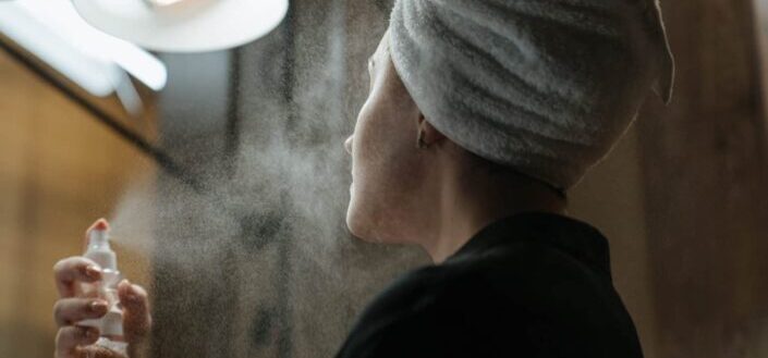 woman spraying on her face