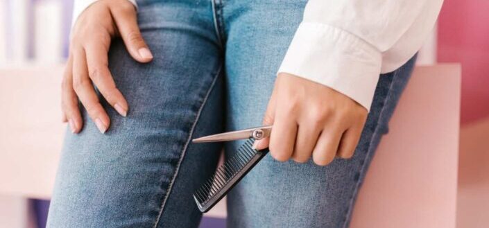 Person holding a comb and silver scissor
