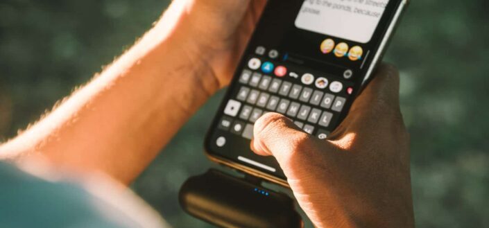 Person sending messages with emoticons on smartphone