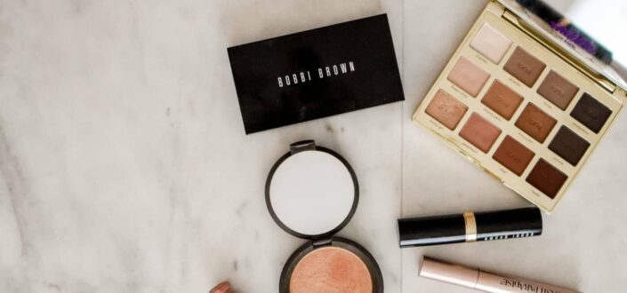 assorted makeup products on gray surface