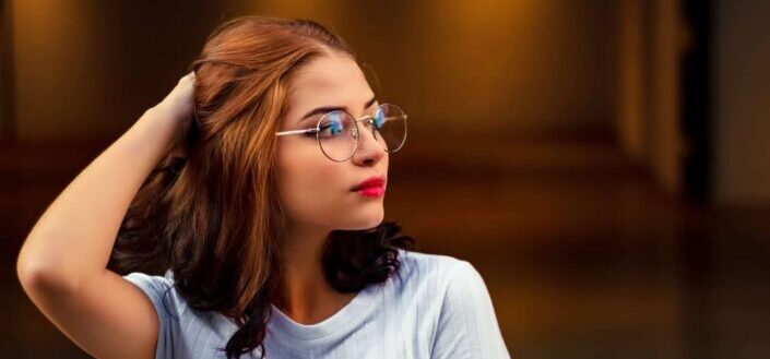 woman wearing eyeglasses while holding her hair