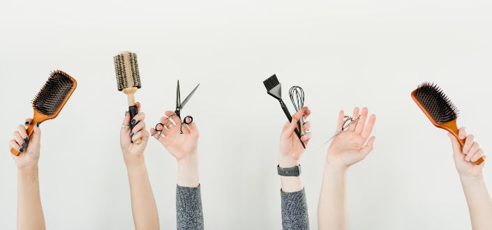 Hands in the air showing combs and scisccors