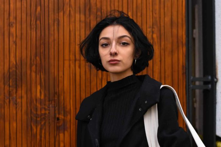woman standing near brown wooden wall