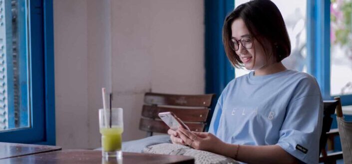 Woman sitting on chair holding a phone