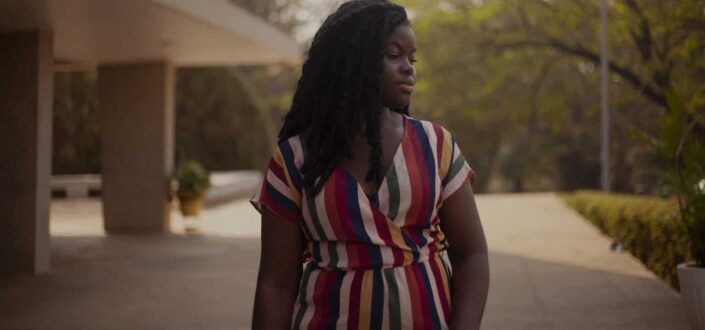 Woman in colorful striped dress on sidewalk