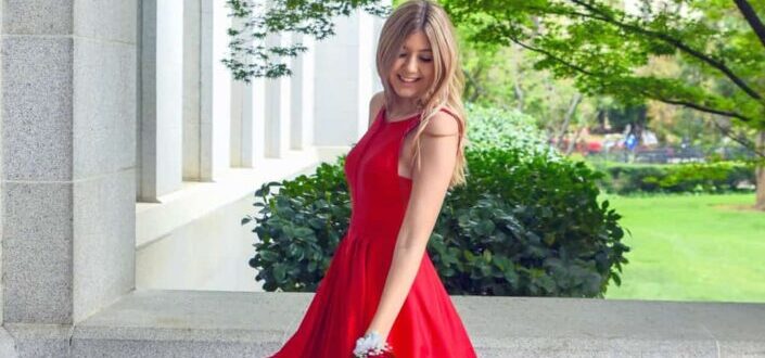 woman in red sleeveless dress standing outside