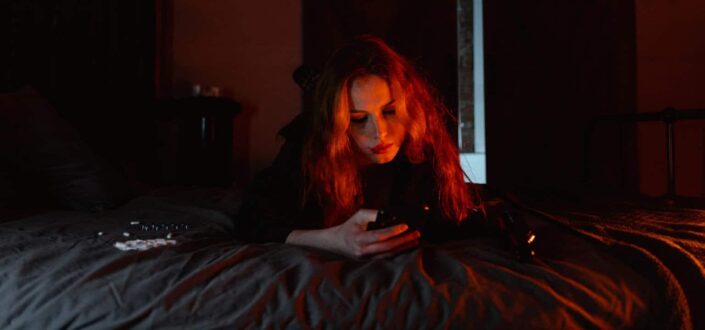 Woman lying on bed with cellphone