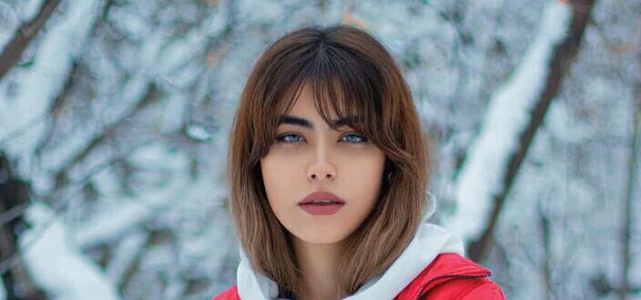 Blue eyed woman in snowy forest