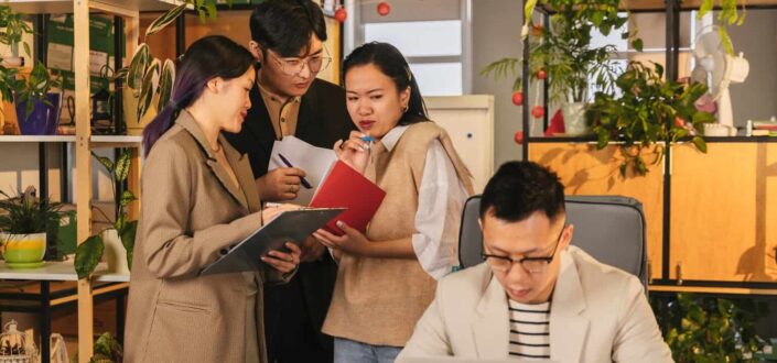 colleagues gossiping behind boss